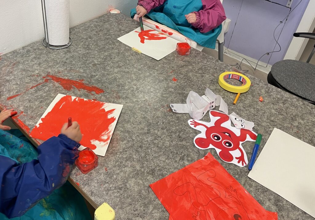 Barn utforskar röd färg på bord